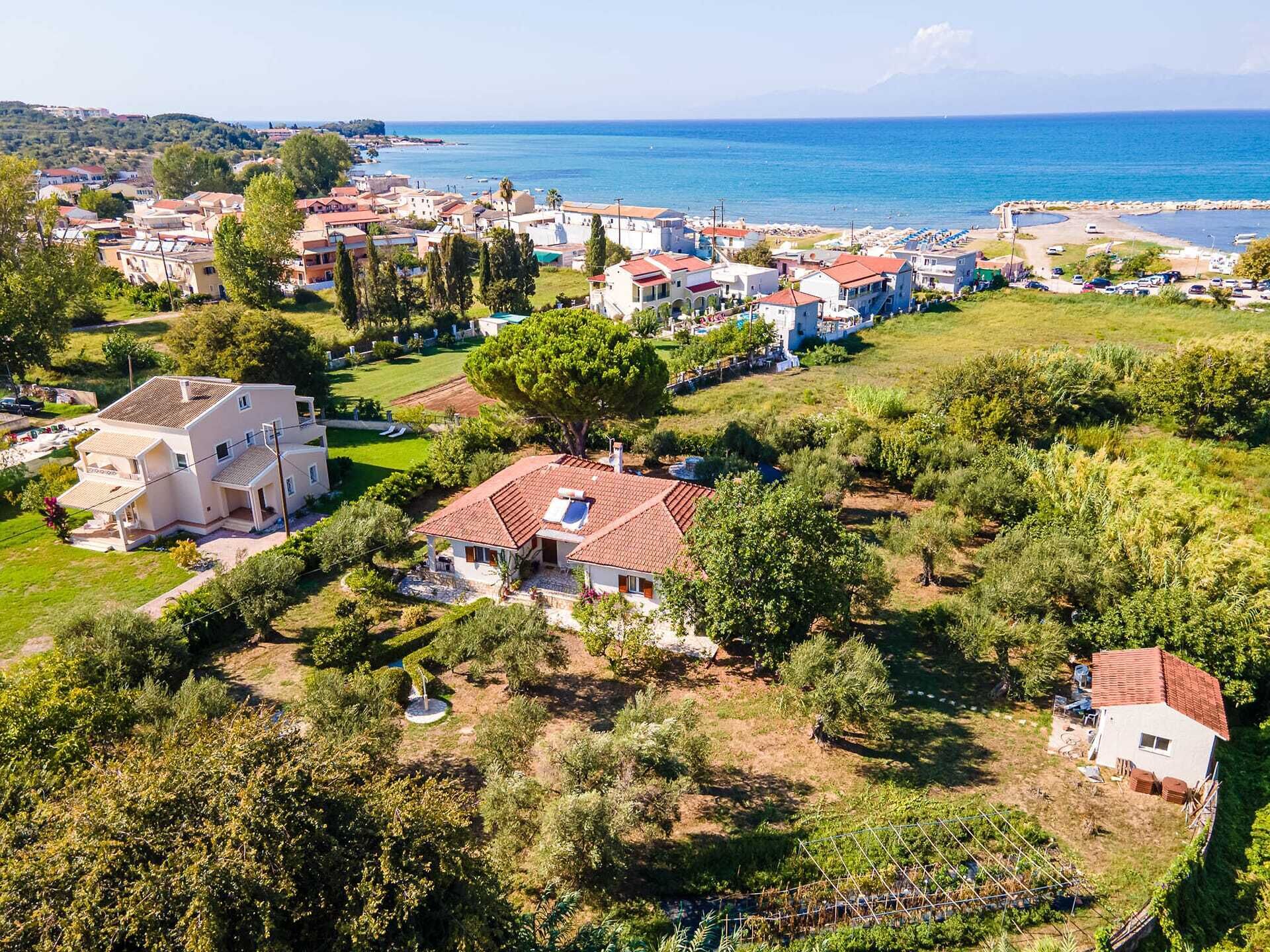 A coastal residential area with houses, a beach, and a clear view of the sea.