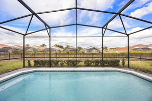 A swimming pool with a metal roof structure, surrounded by a fence and greenery. - Davenport Villa 5BR Retreat, Sleeps 12 (Davenport)