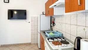 A kitchen with a gas stove, a sink, and a blue dish rack.