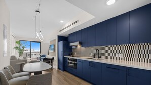 Eine moderne Küche mit blauen Schränken, einer weißen Arbeitsplatte und einer gemusterten Spritzschutzwand.