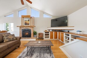 Un salón amplio con chimenea, televisor y una zona de estar acogedora.