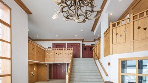 Ein geräumiger Innenraum mit einer Treppe, die zu einer zweiten Etage führt, Holzvertäfelung und einem Chandelier.