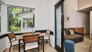 En moderne stue med spiseplads, en sofa og et lille bord med stole.