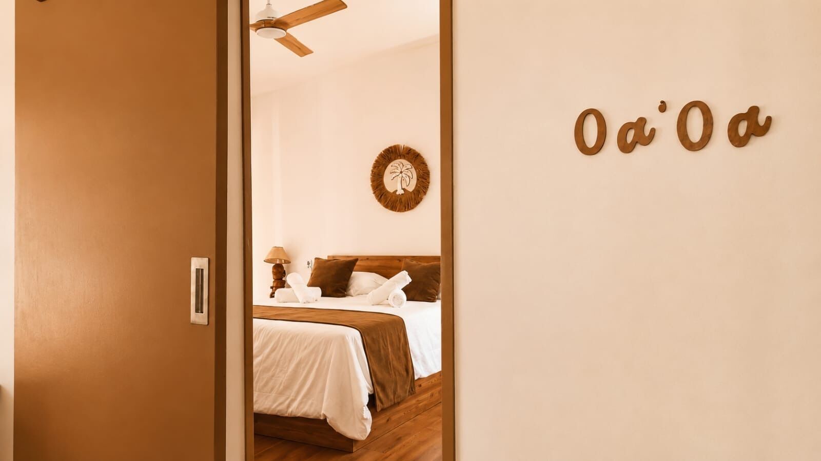 Una habitación de hotel con una cama, un reloj de pared y una puerta con el símbolo del número.