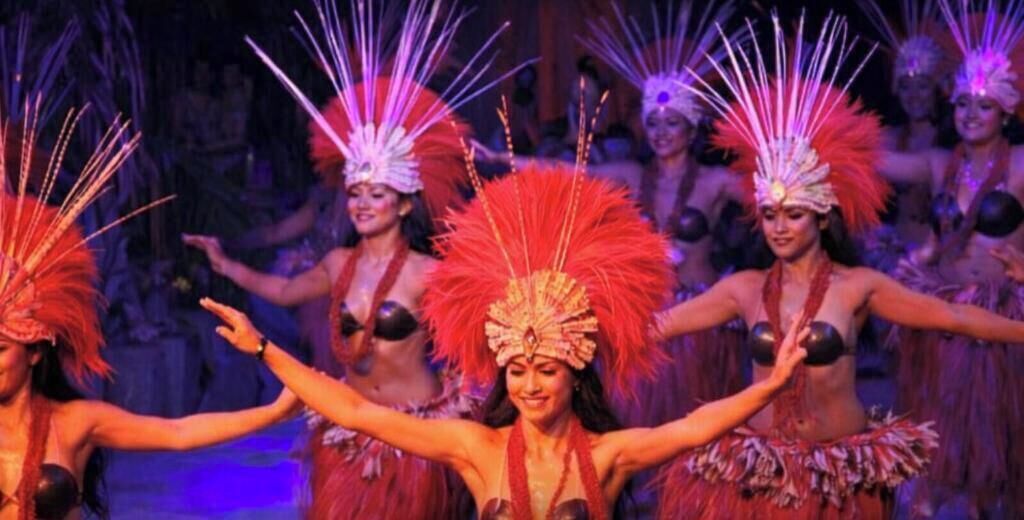 A group of performers in traditional costumes with feathered headdresses.