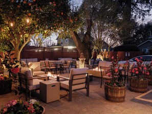 An outdoor patio area with seating arrangements, a fire feature, and decorative lighting. - The Charles Napa, an Artfully Designed Inclusive Inn (Napa)