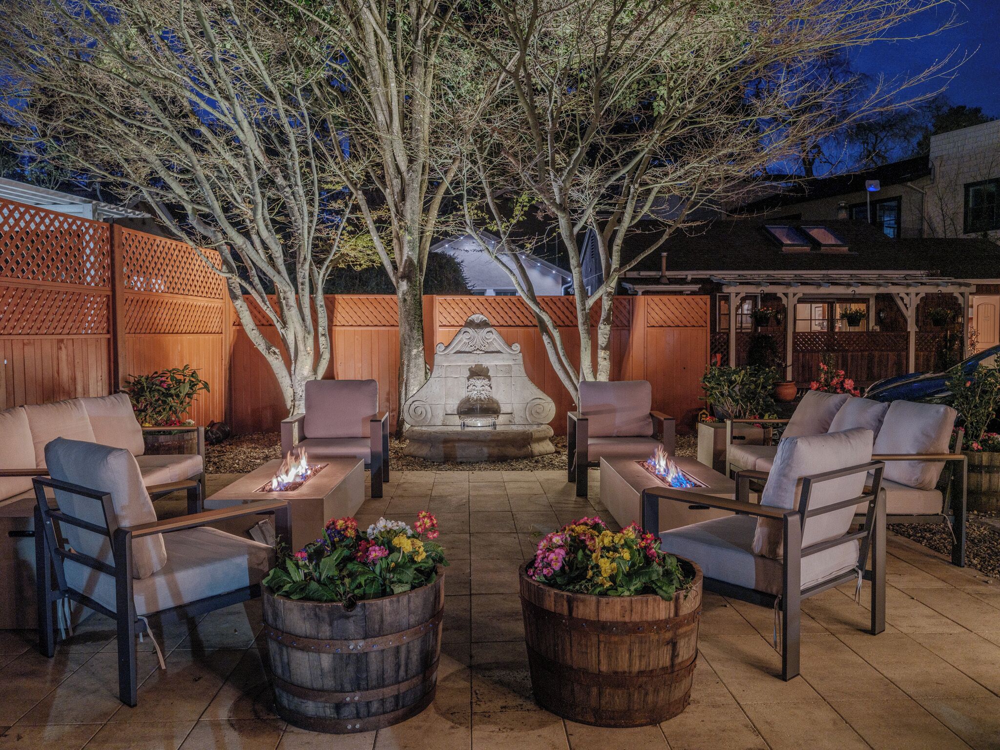 Un espace extérieur aménagé avec une terrasse, un foyer et un élément décoratif en pierre.