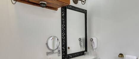 A bathroom with a white toilet, a white sink, a black vanity, and a wooden cabinet above the sink.