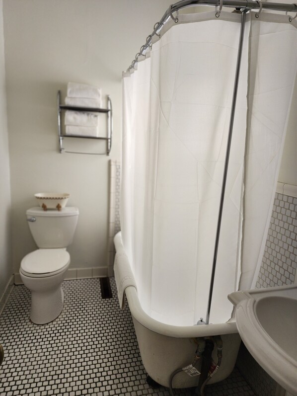 A bathroom with a toilet, a bathtub with a shower curtain, and a sink. - The Charles Napa, an Artfully Designed Inclusive Inn (Napa)