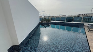 Una piscina en la azotea con vistas despejadas del horizonte de la ciudad.