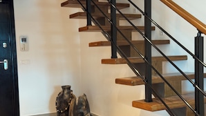 Una escalera con escalones de madera y barandillas de metal negro.