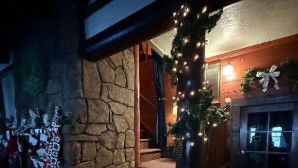 Una escalera con un muro de piedra a un lado y suelo de madera.