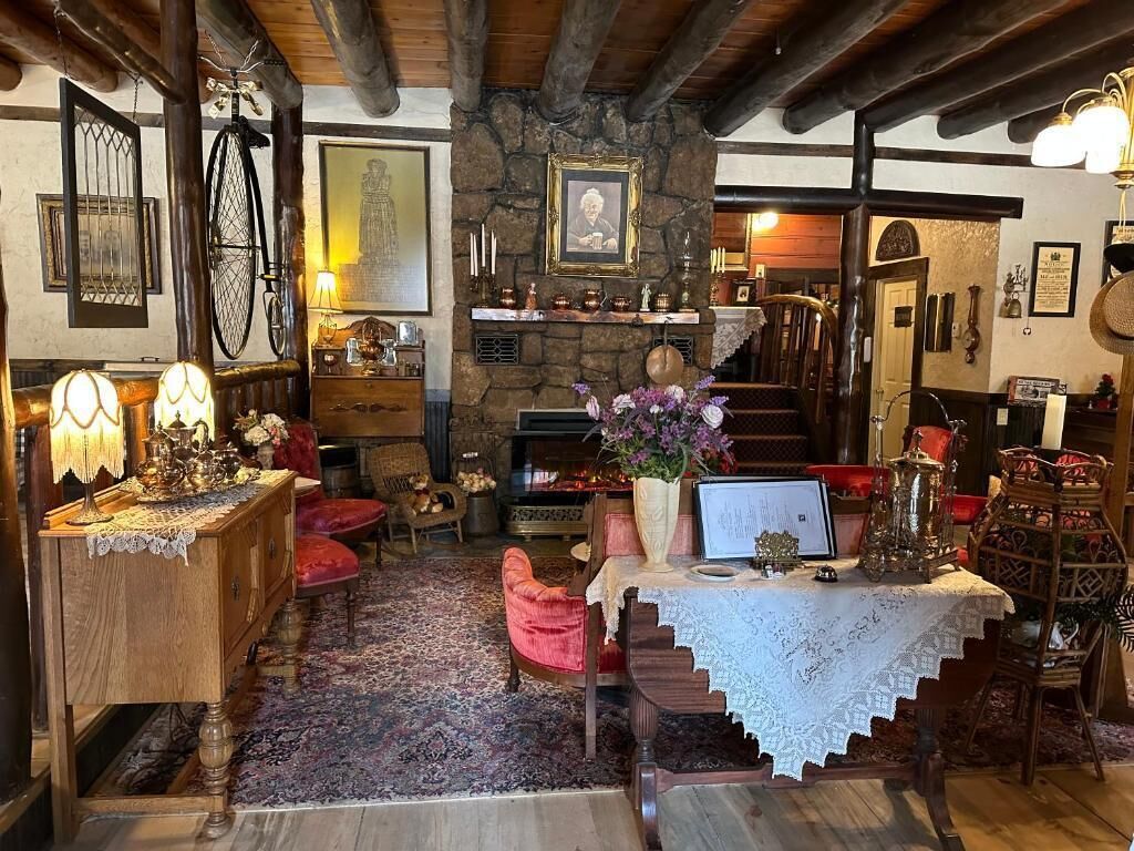 A cozy, rustic interior with a stone fireplace, wooden beams, and traditional furnishings.