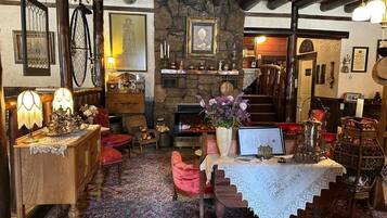 A cozy, rustic interior with a stone fireplace, wooden beams, and traditional furnishings.