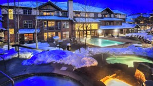 Een resort met meerdere gebouwen, een zwembad en sneeuw bedekte grond.