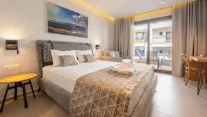 Ein Hotelzimmer mit einem großen Bett, einem Schreibtisch, einem Sessel, einem Gemälde und Blick ins Freie.