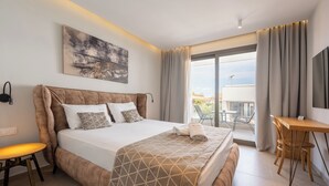 Ein modernes Hotelzimmer mit einem großen Bett, einem Schreibtisch und einem Balkon mit Blick.