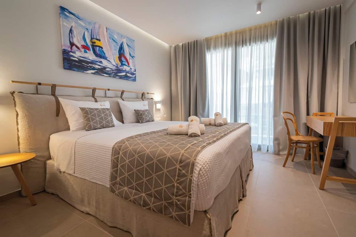 Een hotelkamer met een groot bed, een bureau en een stoel.