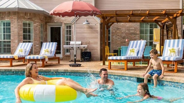 A swimming pool area with lounge chairs and a pergola. - Upscale Escape • Pool, Hot Tub, Game Room, Firepit (San Antonio)