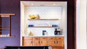 A pool table in a room with wooden cabinets, a white tiled backsplash, and shelves with various items. - Upscale Escape • Pool, Hot Tub, Game Room, Firepit (San Antonio)