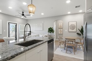 Eine moderne Küche mit Granit-Arbeitsplatte, Edelstahlgeräten und einem Essbereich mit Holzkästen.