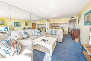 A living room with a sofa set, coffee table, and a dining area with chairs and a table. - South Hampton 3BR Oceanview,Balcony,Steps to Beach (Myrtle Beach)