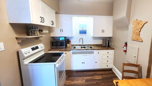 A compact kitchen with white cabinets, a microwave, a toaster, and a sink. - Comfortable 2BR Near Lakewalk with Private Entry & Parking (Duluth)