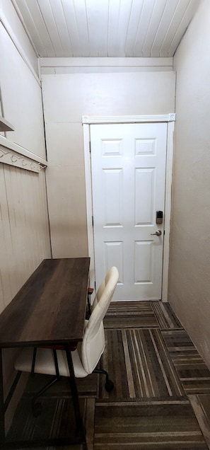 A narrow hallway with a white door, a wooden bench, and a white chair. - Comfortable 2BR Near Lakewalk with Private Entry & Parking (Duluth)