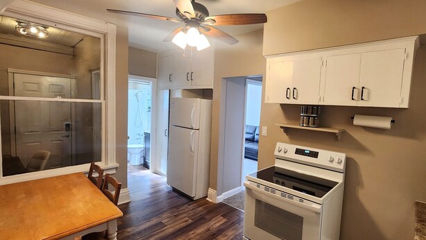 A kitchen with white cabinets, a refrigerator, an oven, and a ceiling fan. - Comfortable 2BR Near Lakewalk with Private Entry & Parking (Duluth)