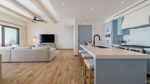 Eine moderne Küche mit einer zentralen Kochinsel, Holzboden und hellblauen Schränken.