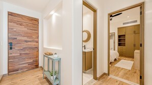 Ein modernes Badezimmer mit Holzboden, Waschbecken und Spiegel.