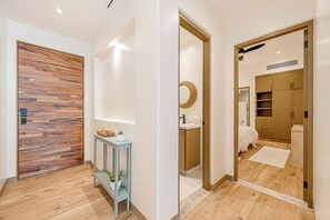 A modern bathroom with a wooden floor, a sink, and a mirror. - Cozy 2-bedroom condo in gorgeous beachfront community (San Jose del Cabo)