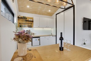 A modern kitchen with white cabinets, a wooden countertop, a built-in fridge, and a vase with flowers on the table. - The Studio | A Slower Stay in Normanville | 5 Mins to the Beach (normanville)