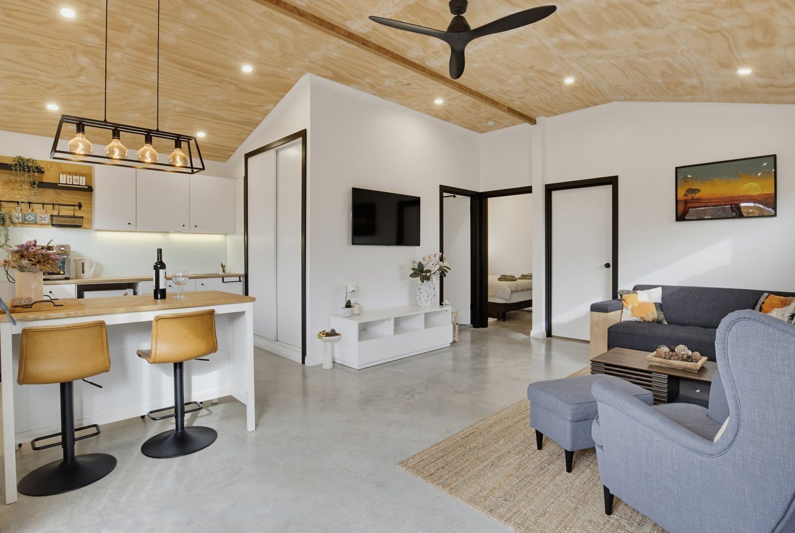 A modern living space with a kitchen, dining area, and seating area.