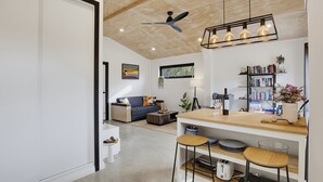 Una cocina moderna con encimera de madera, taburetes de bar y ventilador de techo.