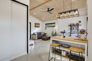 Eine moderne Küche mit Holztischplatte, Barhocker und Deckenventilator.