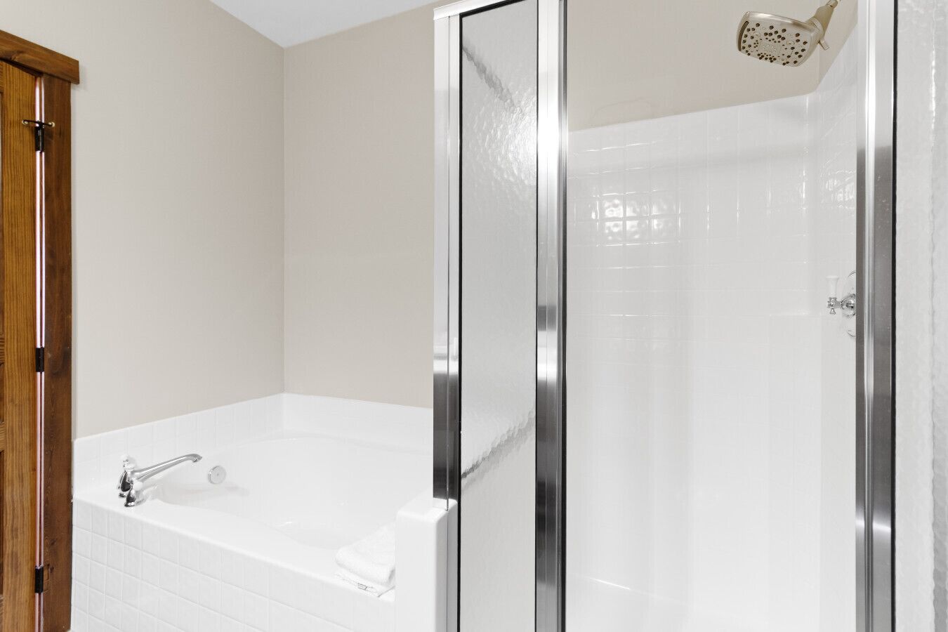 Ein Badezimmer mit einer Badewanne, einer Dusche und einer gläsernen Duschkabine.