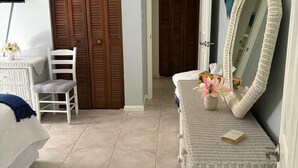 A bedroom with a bed, a chair, a dresser, a mirror, and a closet. - Fabulous Country Apartment in "America's Happiest Seaside Town." (Stuart)