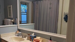 A bathroom with two sinks, a large mirror, and a window with a view of a tree. - Fabulous Country Apartment in "America's Happiest Seaside Town." (Stuart)