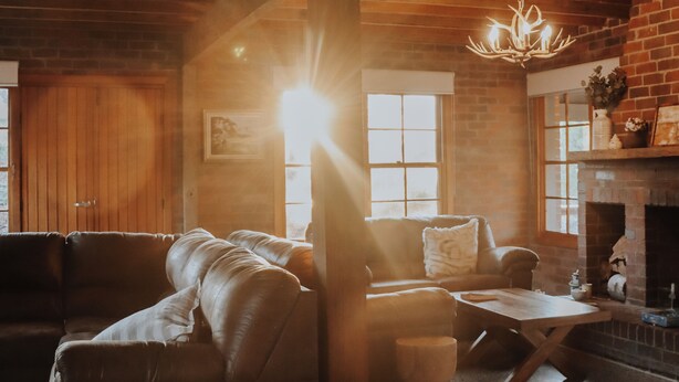 Ein gemütliches Wohnzimmer mit Kamin, Ledersofas und Holzboden.