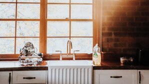 Eine Küche mit Fenster, Spüle und Geschirrgestell.