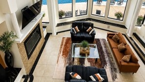 Un salón amplio con chimenea, ventanas grandes y vista a un lago.