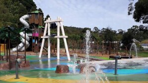 Un área de juegos acuáticos con toboganes y chorros de agua.