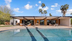 A modern house with a swimming pool, outdoor seating, and palm trees. - Desert Escape- Pool, Spa & Mountain Views (Palm Springs)