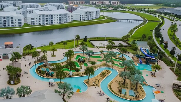 Een waterpark met kronkelende zwembaden, glijbanen en palmbomen.