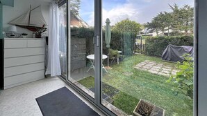 Ein Zimmer mit einer Schiebetür aus Glas, die zu einem Garten führt.