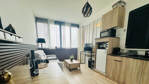 Una sala de estar moderna con un sofá, una mesa de centro y un comedor con cocina.