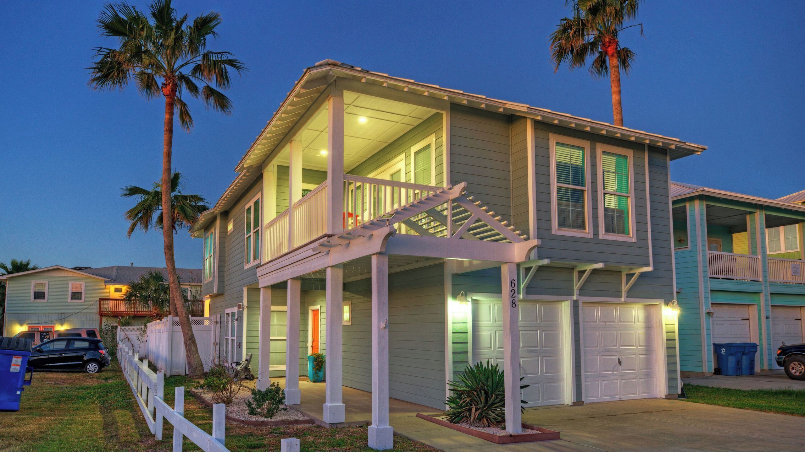 A two-story house with a covered porch, a garage, and a fenced yard.