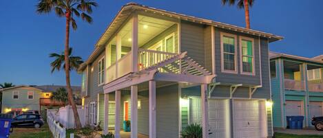 A two-story house with a covered porch, a garage, and a fenced yard.
