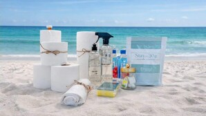 A beach setting with toiletries, towels, and a bag labeled 'Stay on 30a.' - Prescription for Paradise by Stay on 30a (Santa Rosa Beach)